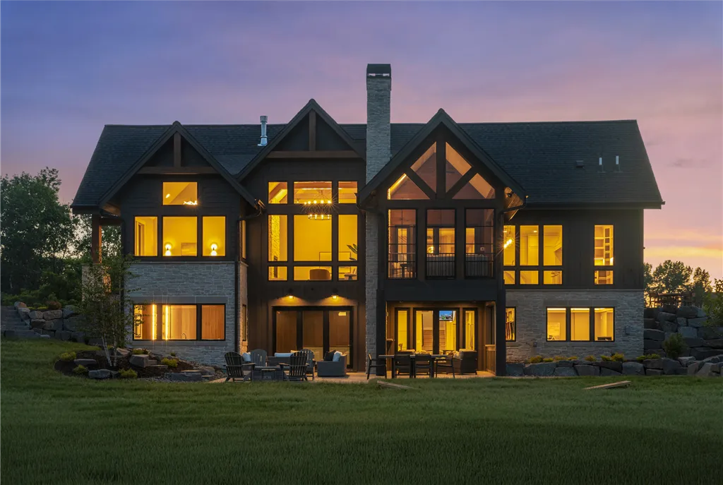 Elegant suburban home with a lawn and driveway at twilight.