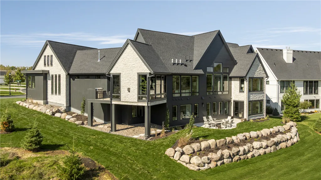 Modern upscale suburban home with a spacious lawn and driveway.