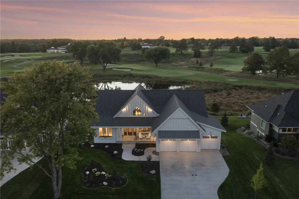 Aerial view of a lakeside mansion with a garden and lawn.