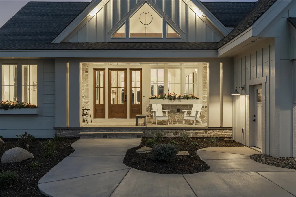 Front exterior of a luxury suburban home with a porch and elegant doorway.