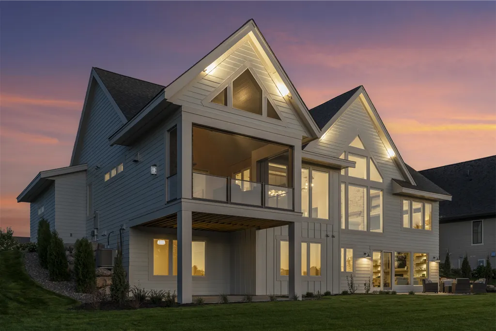 Rear angle view of a luxury suburban home with a driveway and lawn.