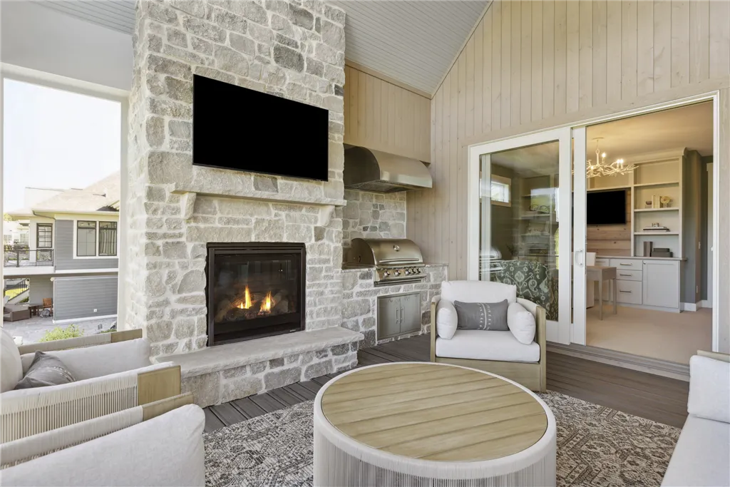 Contemporary family room with fireplace in a four-season porch, featuring modern furniture and large windows.