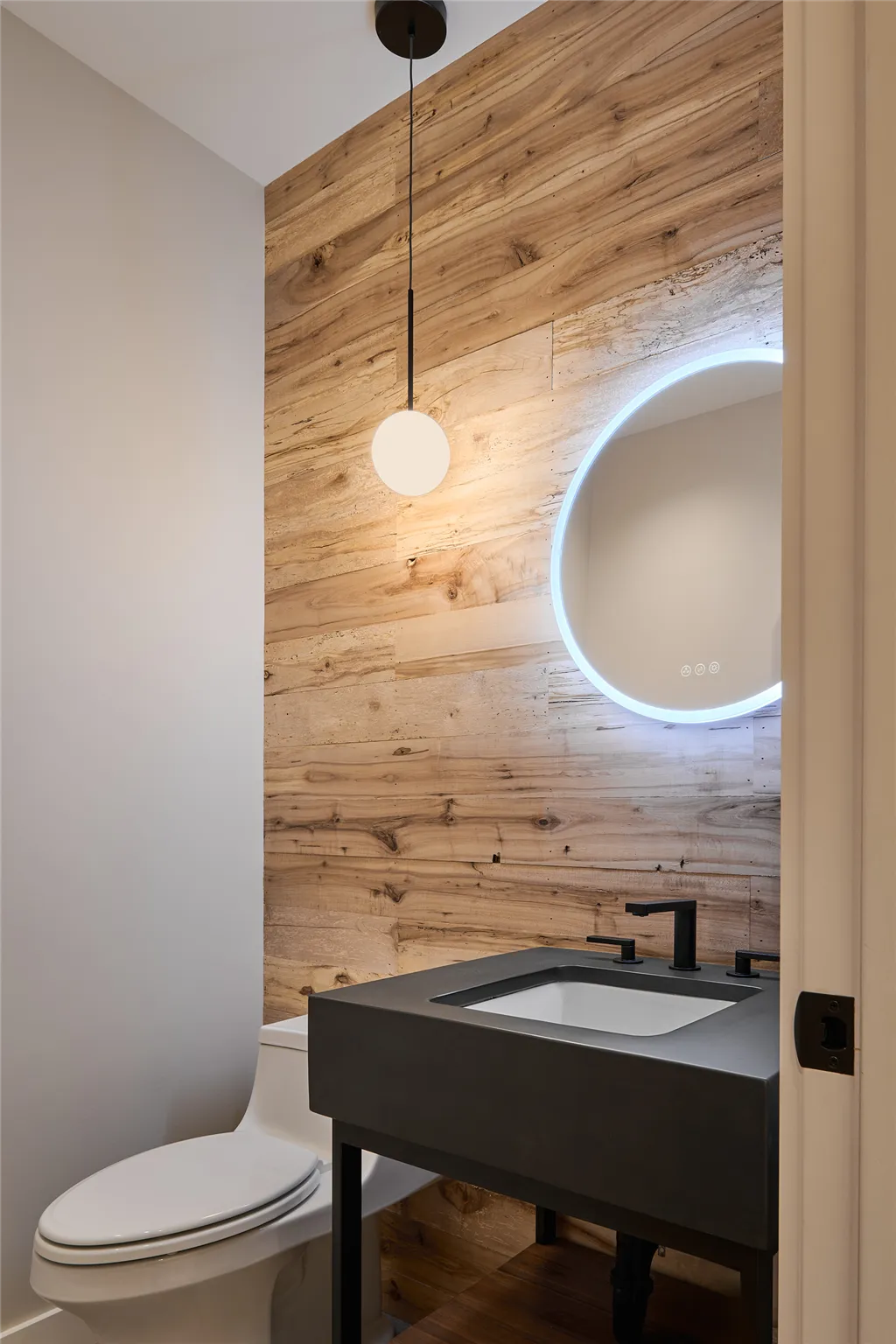 Luxurious contemporary minimalist bathroom with mirror and wooden elements.