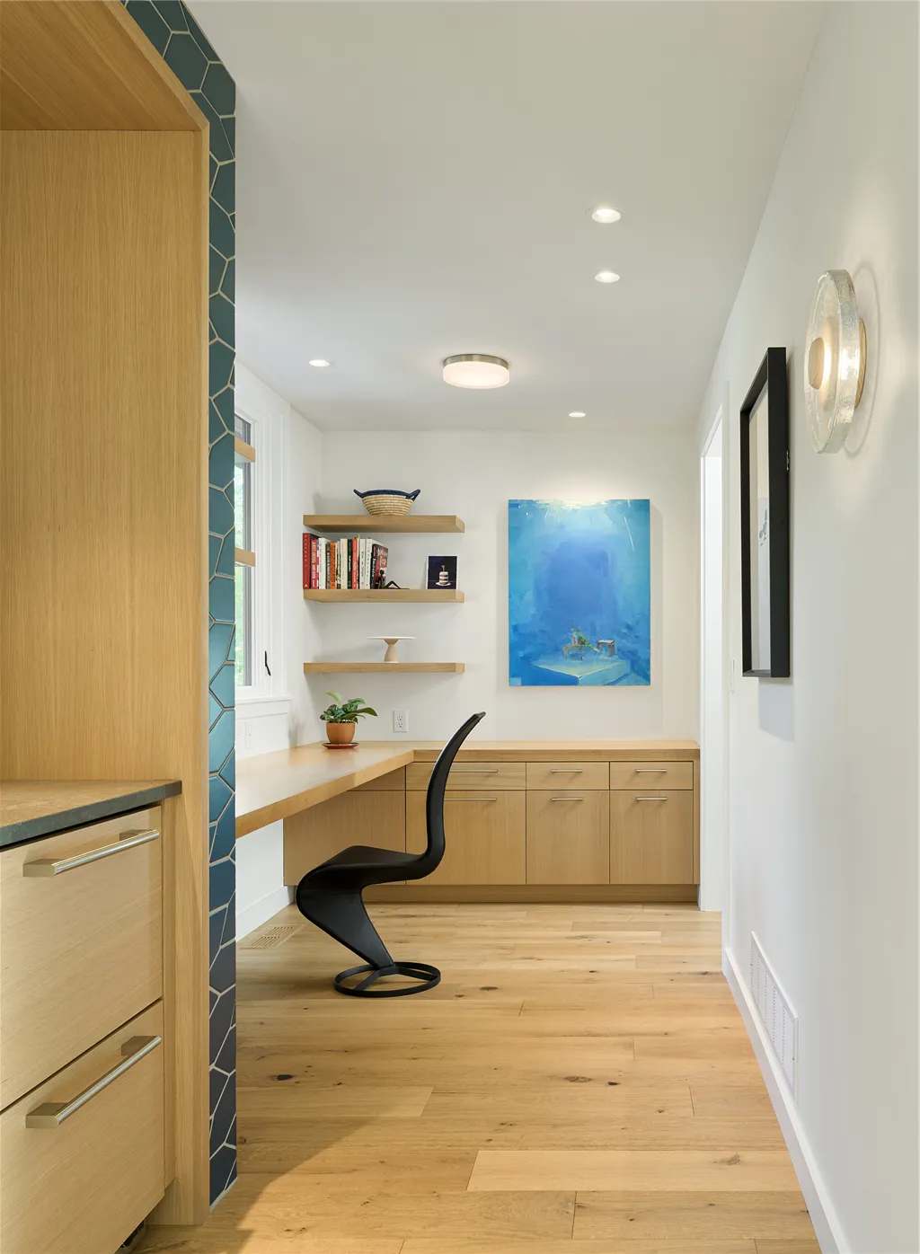 Spacious contemporary minimalist home office with parquet flooring and large windows.