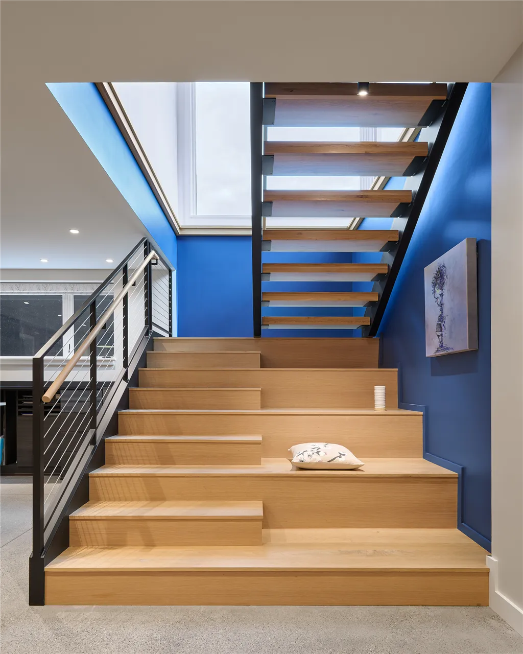 Modern indoor stairway with wooden steps and glass elements in a minimalist design.